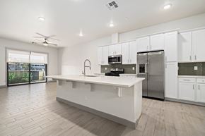 Mesa townhouse for rent - A modern kitchen with white cabinets and a large island.