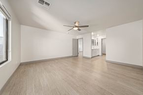 Mesa townhouse for rent - A spacious room with a ceiling fan and light, hardwood flooring, and a window on the left side.