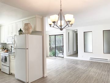San Jose apartment for rent - an open kitchen and living room with white cabinets and a refrigerator