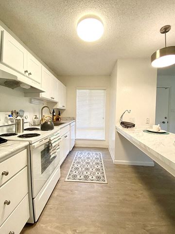 San Jose apartment for rent - a kitchen with white cabinets and a stove and a sink