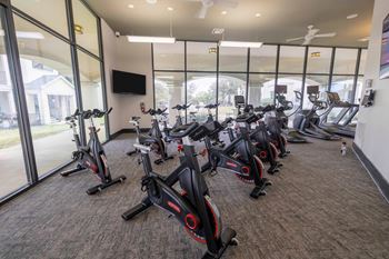 A gym with a row of stationary bikes