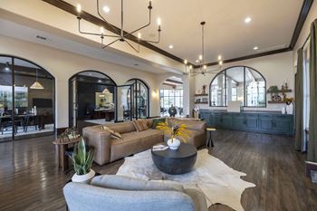 A modern living room with a large sectional sofa and a coffee table in the center
