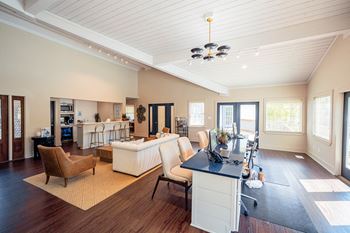 A large living room with a kitchen and a desk