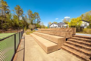 The decks are stacked up next to a tennis court and a fence