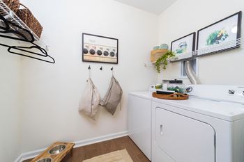 A washer and dryer in a laundry room with pictures on the wall