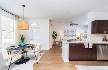 A living room and kitchen with a dining room table and chairs