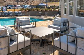 Birmingham apartment for rent - a patio with chairs and a table next to a pool at WildForest Apartments, Birmingham, AL, 35209