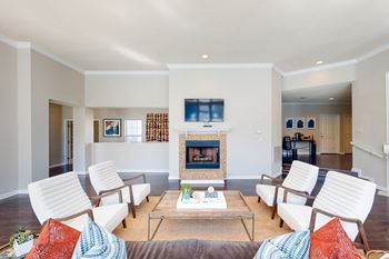 A living room with white furniture and a fireplace