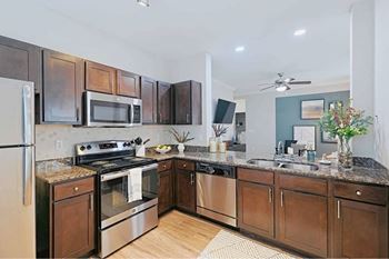 A kitchen with dark wood cabinets and stainless steel appliances