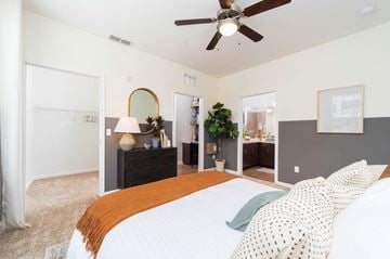 Jacksonville apartment for rent - A bedroom with a large bed and a ceiling fan.