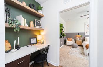 A living room with a desk and a mirror