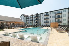 Alcoa apartment for rent - A large swimming pool with lounge chairs and a building in the background.