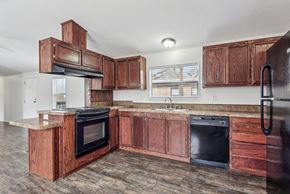 Longmont apartment for rent - A kitchen with wooden cabinets and black appliances.