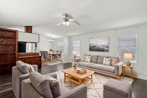 Longmont apartment for rent - A living room with a grey couch, a wooden coffee table, and a painting on the wall.