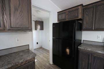 Rock Springs apartment for rent - a kitchen with a black refrigerator and wooden cabinets