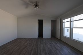 Rock Springs apartment for rent - an empty living room with wood floors and a ceiling fan at Horizon MHC, Rock Springs, 82901