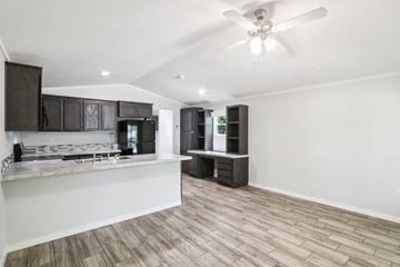Austin apartment for rent - A spacious kitchen with dark brown cabinets and a white ceiling fan.