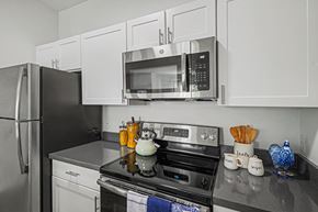 Littleton apartment for rent - A modern kitchen with a black stove top and white cabinets.