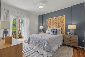 Littleton apartment for rent - A bedroom with a bed, nightstands, and a window with curtains.