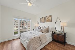 Littleton apartment for rent - A bedroom with a large bed and a ceiling fan.