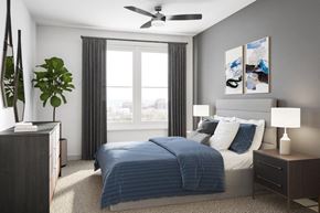 Colorado Springs apartment for rent - A bedroom with a bed, nightstand, and a plant.
