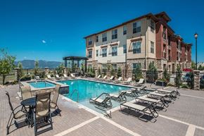 Colorado Springs apartment for rent - A large building with a pool in front of it.