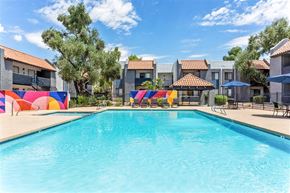 Glendale apartment for rent - A swimming pool in front of a row of houses with a blue sky above.