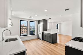 Cambridge apartment for rent - 440-7 a kitchen with white countertops and black appliances and a large window