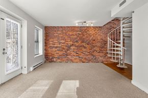 Cambridge apartment for rent - A room with a red brick wall and a white door.