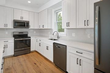 Cambridge apartment for rent - a kitchen with white cabinets and stainless steel appliances