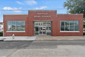 Suffolk apartment for rent - the front of a brick news herald building with a fire hydrant