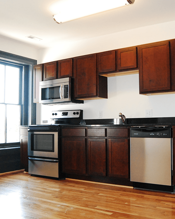Suffolk apartment for rent - A kitchen with wooden cabinets and a black dishwasher.