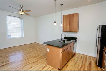 Portsmouth apartment for rent - A kitchen with wooden floors and a black countertop.
