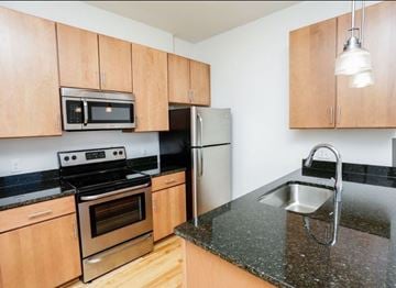 Portsmouth apartment for rent - A kitchen with wooden cabinets and granite countertops.