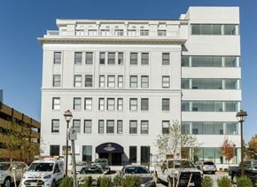 Portsmouth apartment for rent - A white building with a black awning and cars parked in front.