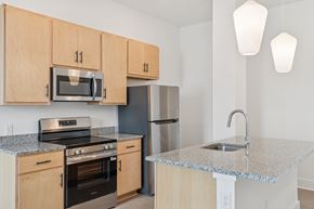 Newport News apartment for rent - A kitchen with a granite countertop and stainless steel appliances.
