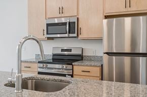 Newport News apartment for rent - A kitchen with a stainless steel refrigerator, microwave, and oven.
