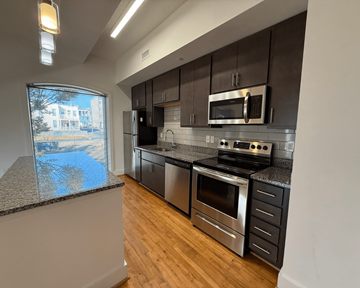 Richmond apartment for rent - A modern kitchen with stainless steel appliances and wooden floors.