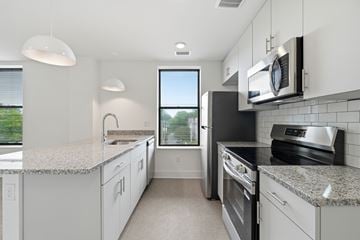 Norfolk apartment for rent - A kitchen with white cabinets and granite countertops.