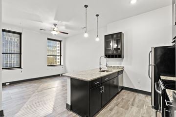 Richmond apartment for rent - A kitchen with black cabinets and a marble countertop.