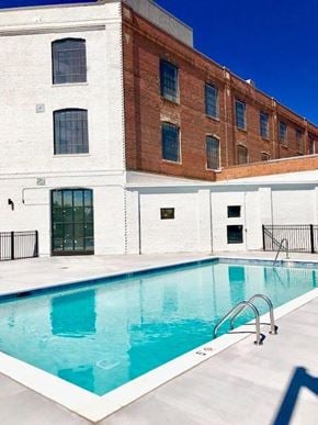 Norfolk apartment for rent - A swimming pool in front of a white and brick building.