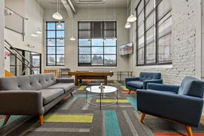 Richmond apartment for rent - A modern living room with a grey sofa, blue armchair, and a coffee table.