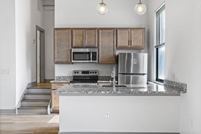 Richmond apartment for rent - A kitchen with a stainless steel refrigerator, microwave, and oven.