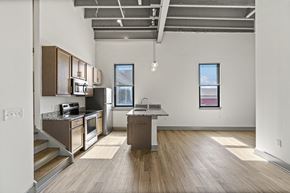 Richmond apartment for rent - A kitchen with wooden floors and a large island in the middle.