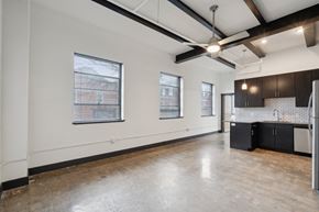 Richmond apartment for rent - A large empty room with a kitchen area on the right side.