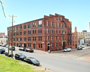 Richmond apartment for rent - A red brick building with a black car in front of it.