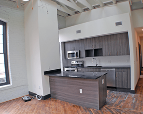 Richmond apartment for rent - A kitchen island with a black countertop and wooden cabinets.