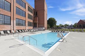 Martinsburg apartment for rent - A swimming pool on a rooftop with lounge chairs and a building in the background.