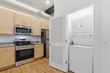 Martinsburg apartment for rent - A kitchen with wooden cabinets and a white fridge.