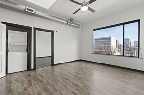 Richmond apartment for rent - A room with a ceiling fan and a window overlooking a cityscape.
